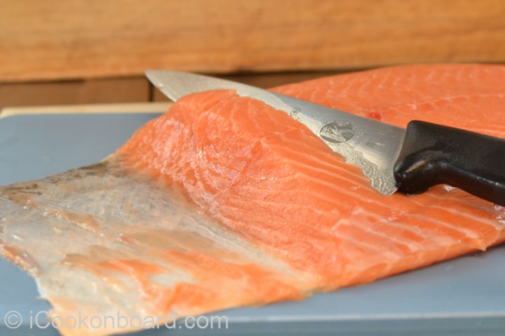 Use a fillet knife if available. Lie salmon fillet  on chopping board skin side down.